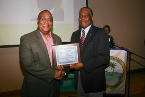 Grand Bahama Chamber of Commerce (GBCC) President Kevin D. Seymour (left) presents Dr Marcus Bethel with a plaque in appreciation of his presentation on the Hawksbill Creek Agreement Review Committee's recommendations during the GBCC's monthly meeting. (Photo: Keen i Media Ltd.) 